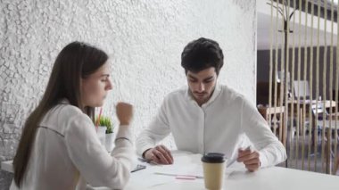 Genç uzmanlar içeride önde gelen şirketlerin masasında çalışıyor ve konuşuyorlar..