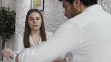 İki iş arkadaşı modern ofiste raporları tartışıyor..