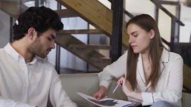 İşadamları koltukta otururken şirketin mali durumunu tartışıyorlar.