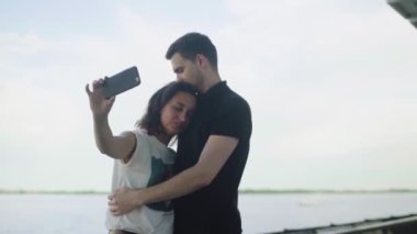 Romantik mutlu çift doğada telefonla fotoğraf çekiyor..