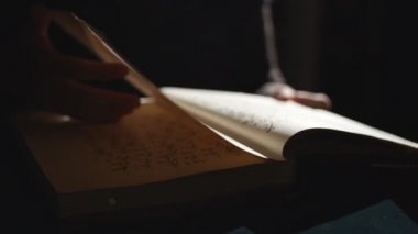 Birileri karanlıkta eski kitapları karıştırıyor.