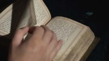 Birisi eski bir Slavonik kitabı karıştırıyor.