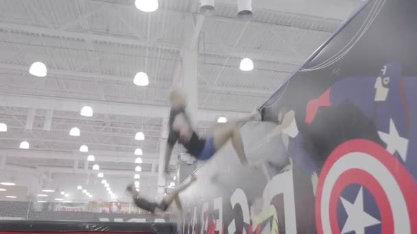 Dos acróbatas saltan a una pared usando un trampolín — Vídeos de Stock