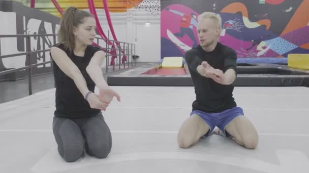 Ο εκπαιδευτής δείχνει πώς να τεντώσει τους μυς και τους συνδέσμους — Αρχείο Βίντεο