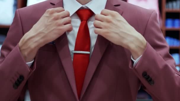 Успішний бізнесмен в червоній куртці в бутіку — стокове відео