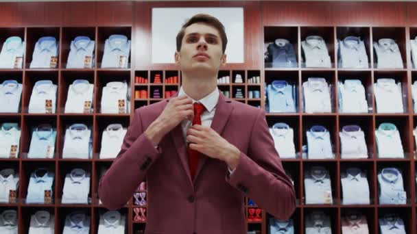 Мужчина покупает костюм в магазине — стоковое видео