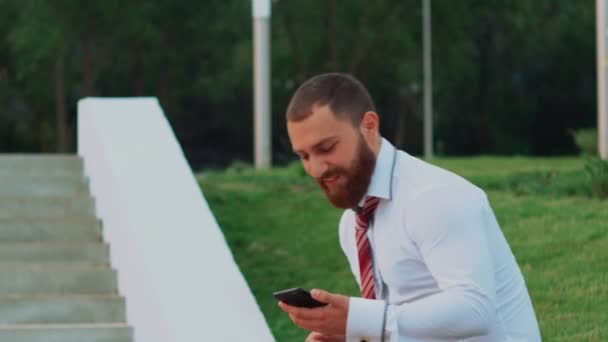 Atractivo hombre de negocios mirando un teléfono móvil, sintiéndose feliz y dejando — Vídeos de Stock