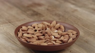 Kadın, yemek için kasesinden bir avuç badem topluyor. Sağ tarafıma fındık kaçtı.