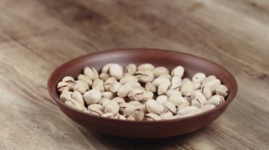 Kadın, yemek için kasesinden bir avuç şam fıstığı alıyor. Sağ tarafıma fındık kaçtı.