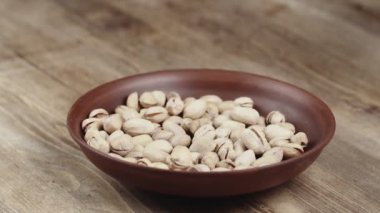 Bir kadın, kasesinden yemek için tek bir fıstıklı alır. Sol tarafıma fındık kaçtı.