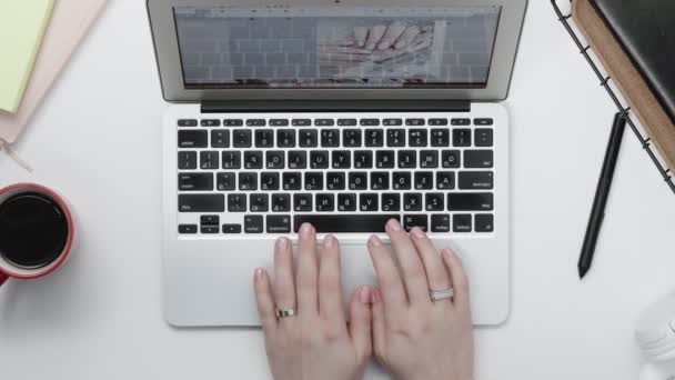 Mãos femininas a escrever no portátil, a beber café. Teclado digitando as mãos. Freelancer workspace overhead POV view — Vídeo de Stock