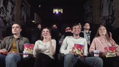 Gençler sinemada komedi filmlerine gülerler. Gençler komik komedi izlerken sinemaya gülüyorlar..