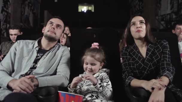 Jeune homme et femme avec un enfant regardent un film. — Video