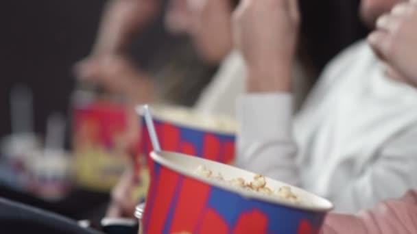 Amigos en el cine viendo películas bebiendo cola y comiendo palomitas de maíz . — Vídeos de Stock