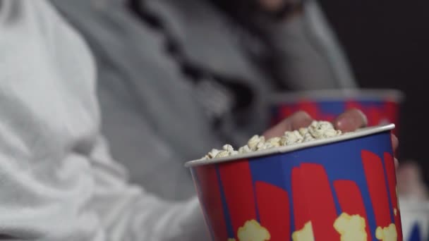 Mannen äter popcorn på bio och tittar på filmen. — Stockvideo