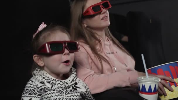 Madre con sua figlia stanno guardando film 3d al cinema. Emozione - sorpresa — Video Stock