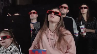 Anne ve kızı 3 boyutlu bir film izliyorlar.