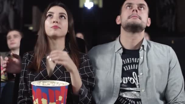 Casal feliz curtindo seu encontro no cinema assistindo a um filme — Vídeo de Stock