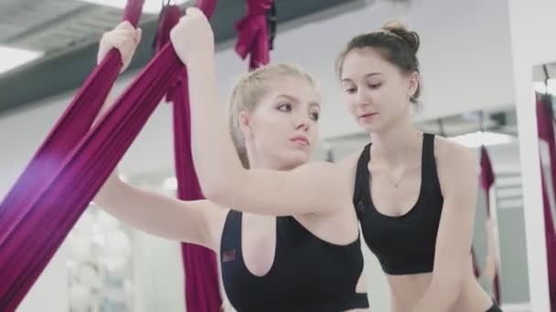 Yoga antigravedad. Chica deportiva comprometida con un entrenador en aeroyoga en el gimnasio — Vídeos de Stock