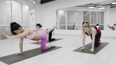 Güzel Yogini kadınları fitness stüdyosunda egzersiz yapıyorlar.