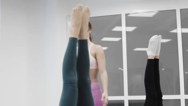 Vrouwelijke yoga instructeur helpt student aan persoonlijke training. Vrouwen praten, lachen en genieten van de training. — Stockvideo