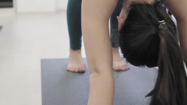 Schöne Frauen praktizieren Yoga unter Aufsicht des Trainers im Sportverein. — Stockvideo