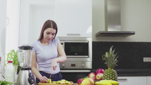 Kobieta pokroiła banana, żeby zrobić koktajl swojemu chłopakowi. — Wideo stockowe