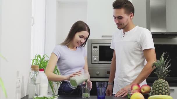 Junge Familie am Morgen trinkt Smoothie aus Obst und Gemüse mit Milch zum Frühstück haben sie ein gesundes Leben und einen gesunden Körper — Stockvideo