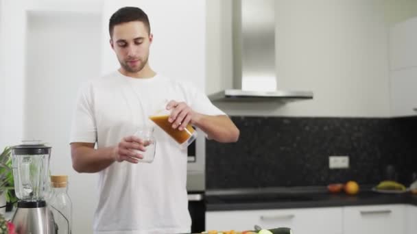 El hombre está vertiendo jugo fresco en un frasco — Vídeos de Stock