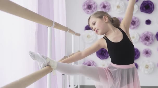 Liten ballerina stretching samtidigt hålla balett barre — Stockvideo