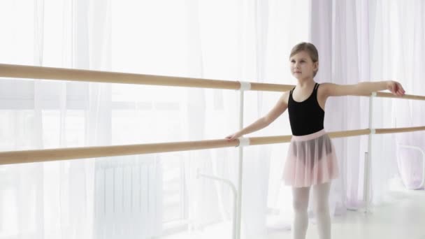 검은 색 과 핑크 색 댄스 복을 입고 훈련받고 있는 작은 발레리나. — 비디오