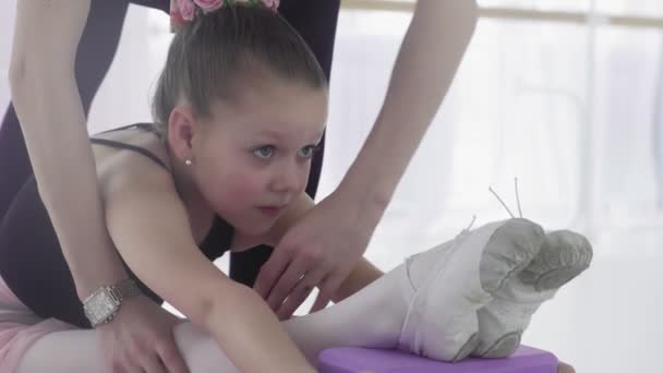 Primo piano di Ballet insegnante ballerina professionista aiutare ragazza sgranchirsi le gambe — Video Stock