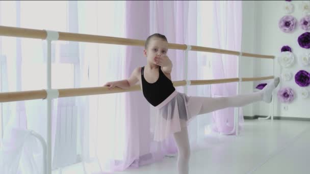 Niña usando la barra de ballet al hacer ejercicios en el estudio de danza — Vídeos de Stock