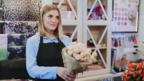 La florista chica está vendiendo un ramo al dueño de la floristería Hombre de la tienda — Vídeo de stock