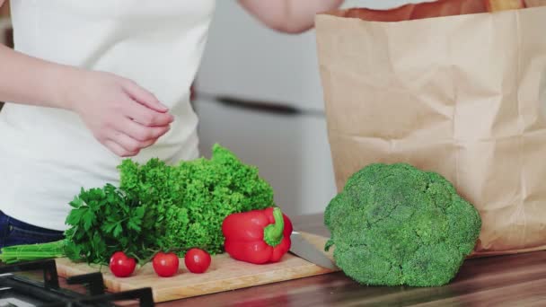 Gros plan du sac d'épicerie féminin déballé avec des légumes dans la cuisine moderne. — Video