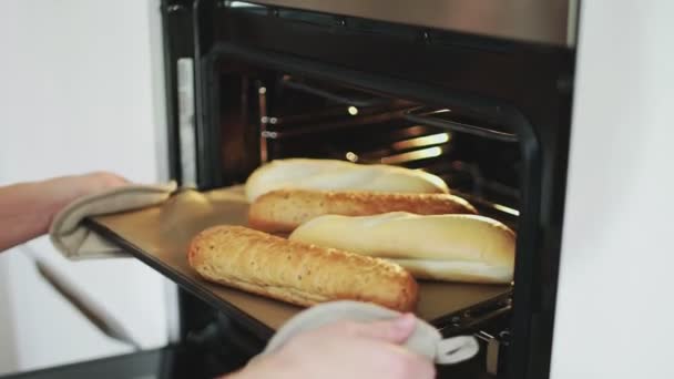 Une femelle met du pain au four.