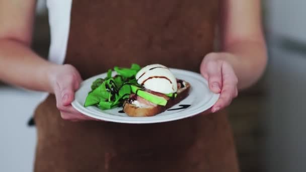 Женщина держит брускетту с авокадо, кипящее яйцо, лосось и творог — стоковое видео