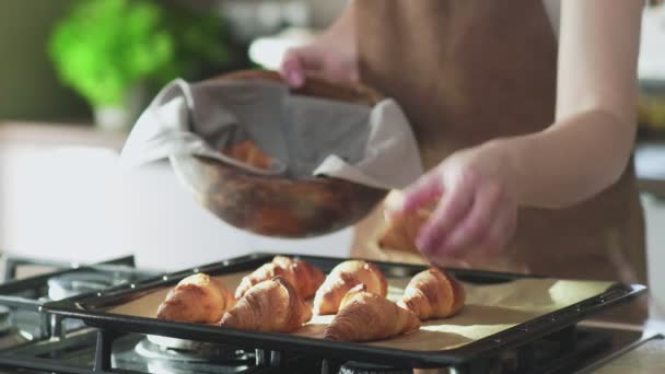 Mujer poniendo croissants cocidos en un tazón de madera — Vídeo de stock