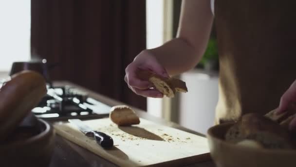 Woman hands putting cutted bread into the wooden bowl — Stock Video