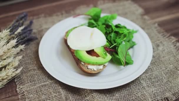 Vista superior de Bruschetta con salmón, aguacate, requesón y huevo escalfado — Vídeos de Stock