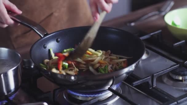 Γυναίκα τηγάνισμα λαχανικών σε τηγάνι γουόκ στο σπίτι — Αρχείο Βίντεο