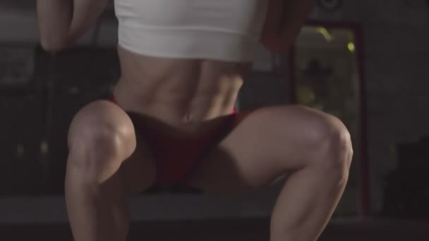 漂亮的女运动员在体育馆里做蹲姿锻炼 — 图库视频影像