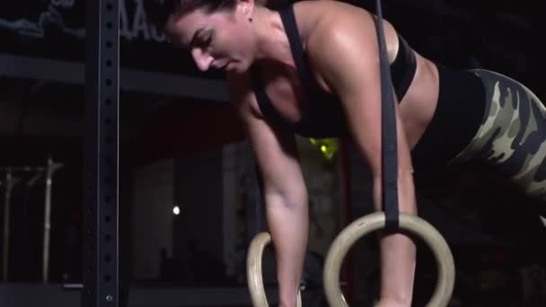 Muskulös kvinna gör armhävningar på gymnastik ringar — Stockvideo
