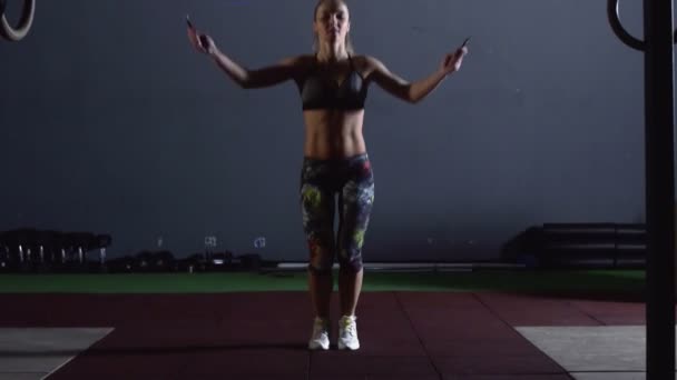 Stark atletisk kvinna övningar med hoppa rep i en Loft Style Industrial Gym. — Stockvideo