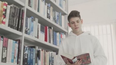 Okul kütüphanesinde kitap okuyan öğrenci. Sınav için ders çalış..