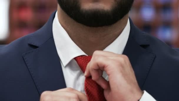 Baard man handen gecorrigeerd rood strik op een wit shirt — Stockvideo