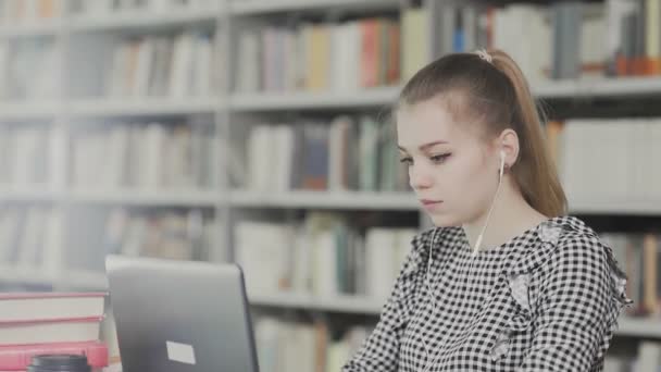 Komoly lány diák dolgozik laptop könyv a városi könyvtárban — Stock videók