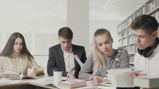 Grupp elever läser bok i skolan — Stockvideo