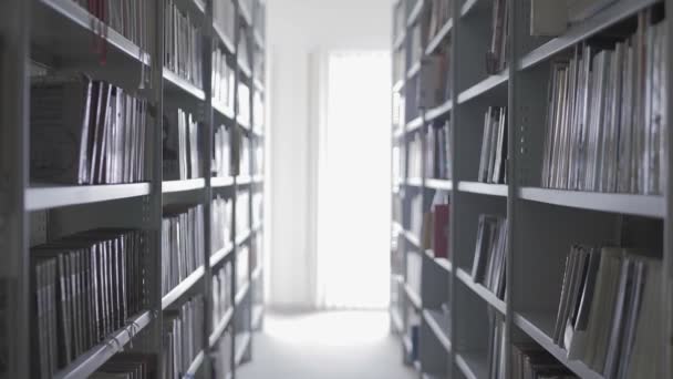 Estanterías en la biblioteca universitaria con muchos libros — Vídeos de Stock