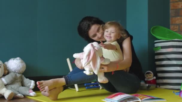 Madre e hija jugando con conejito de peluche — Vídeos de Stock